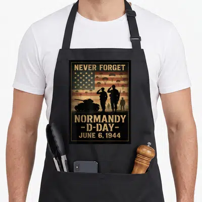 82st military apron - Soldier silhouettes saluting tank and parachutes over distressed US flag with D-Day text — shown on a black cotton canvas apron against a white background