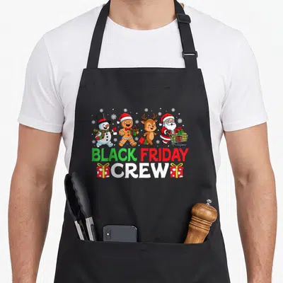 Family black friday apron - Four cartoon Christmas characters above BLACK FRIDAY CREW text flanked by two red gift boxes — shown on a black cotton canvas apron against a white background