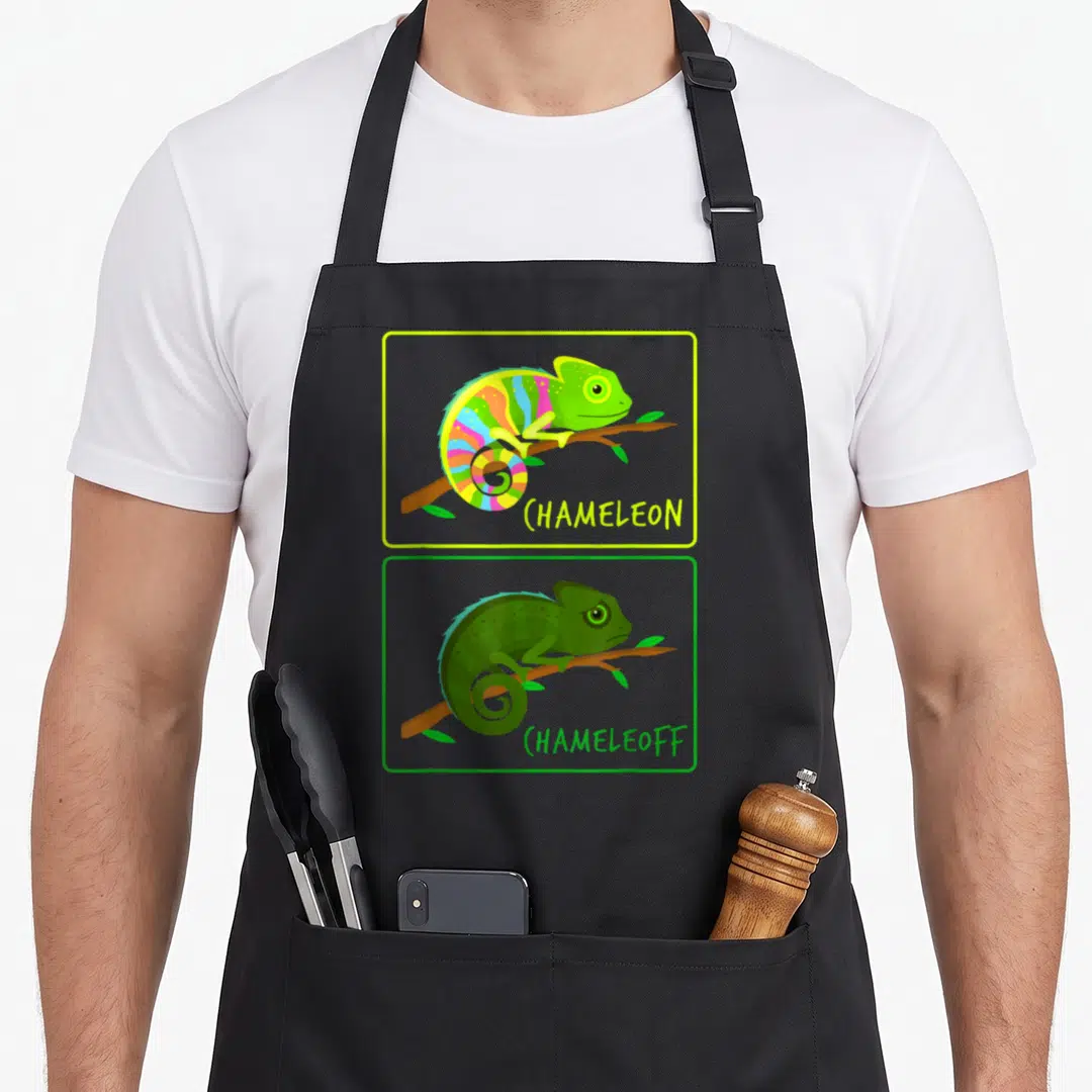 Chameleoff chameleon apron - Cartoon rainbow and green chameleons on branches with text CHAMELEON and CHAMELEOFF below — shown on a black cotton canvas apron against a white background