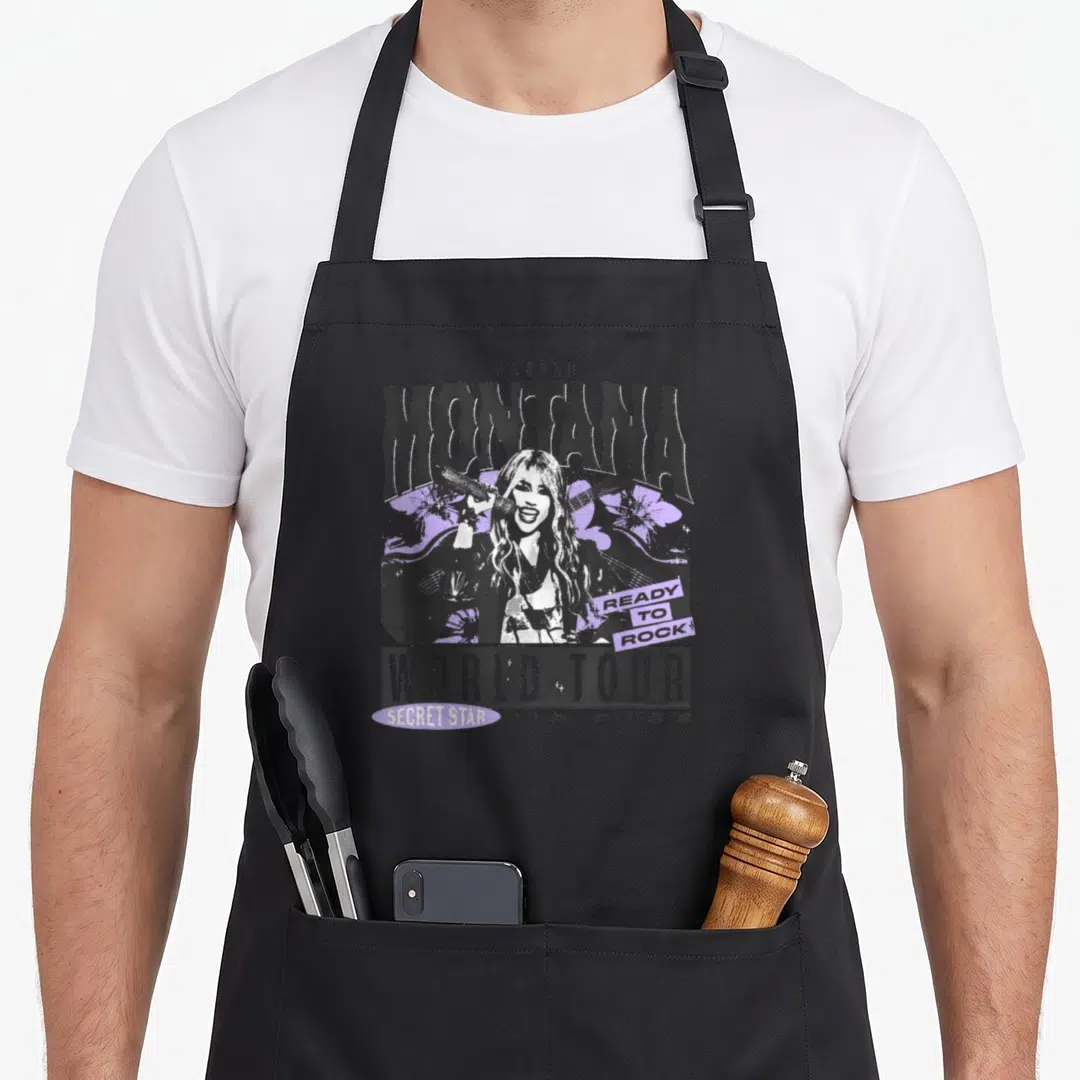 Tour montana girl apron - Retro graphic of a woman holding a mic with guitar and purple flowers surrounded by concert — shown on a black cotton canvas apron against a white background