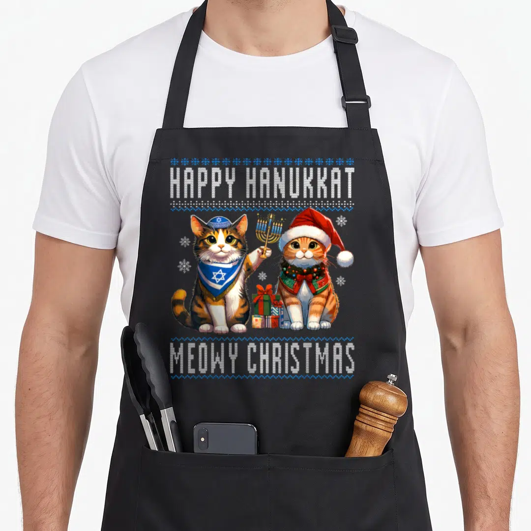 Cat merry christmas apron - Two cartoon cats with menorah and santa hat under happy hanukkat and meowy christmas text — shown on a black cotton canvas apron against a white background