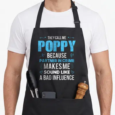 Funny poppy father day apron - Stacked white and blue text reading They Call Me Poppy With Hearts And Arrows — shown on a black cotton canvas apron against a white background