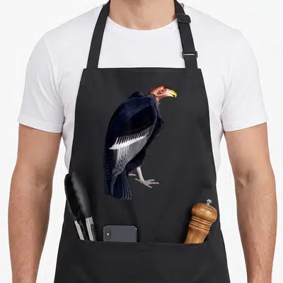 Illustration turkey apron - Realistic vulture illustration with red head, black wings, and white wing bars — shown on a black cotton canvas apron against a white background
