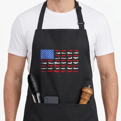 Flag airplane apron - Red and white airplane silhouettes arranged in stripes next to a blue field with white stars — shown on a black cotton canvas apron against a white background