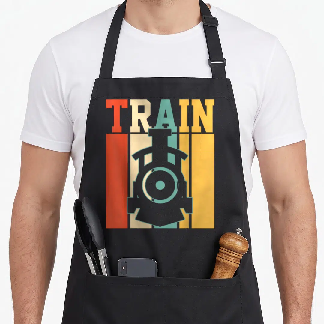 Train model lover apron - Grey train silhouette over red beige teal and yellow stripes with TRAIN text — shown on a black cotton canvas apron against a white background