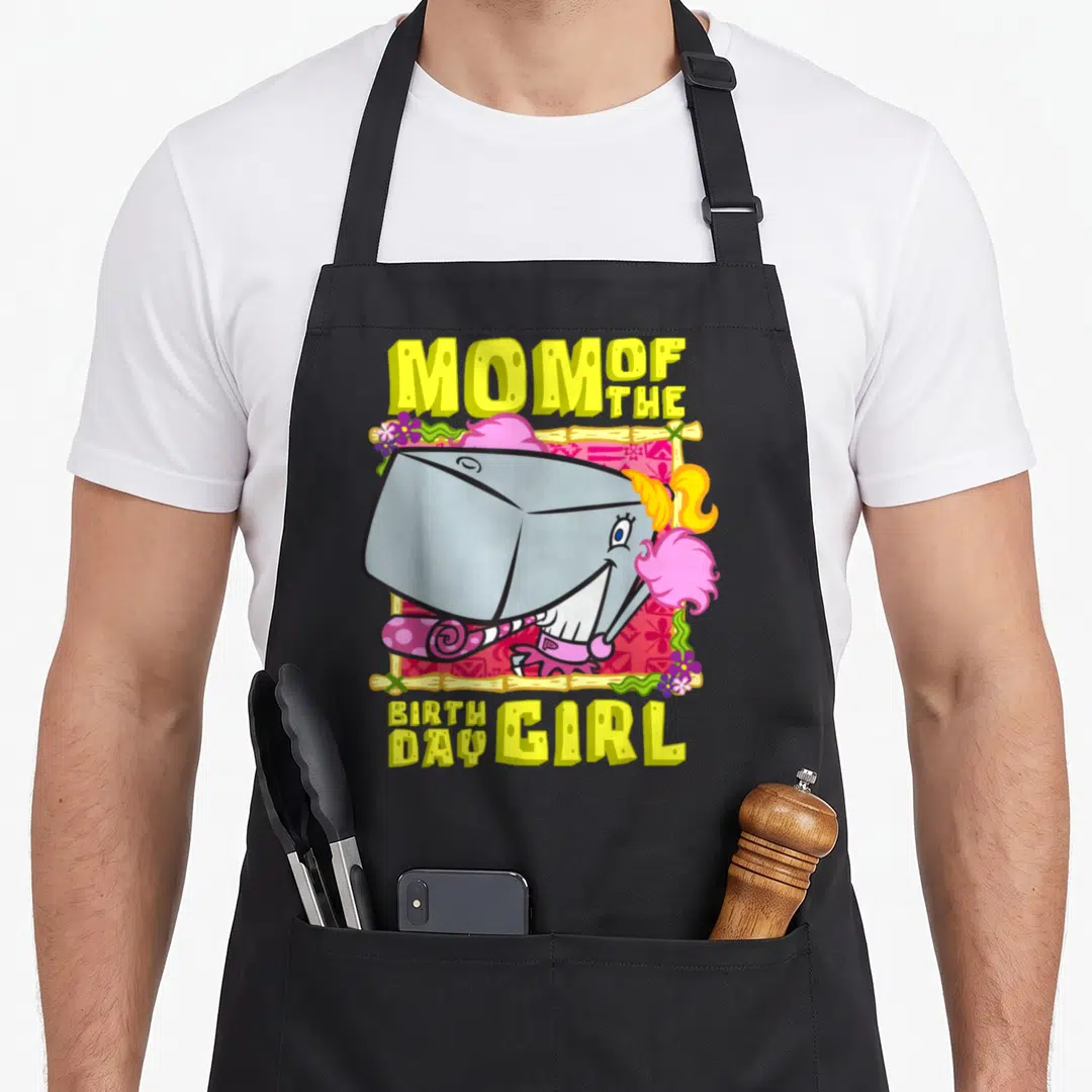 Pearl mother's apron - Cartoon grey shark with pink hair and yellow Mom of the Birthday Girl text — shown on a black cotton canvas apron against a white background