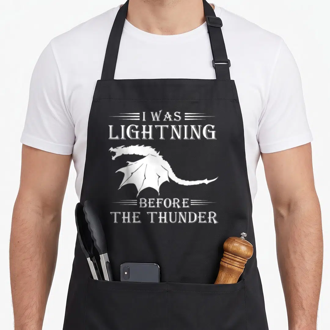 Thunder dragon apron - White dragon silhouette between text I was lightning before the thunder — shown on a black cotton canvas apron against a white background