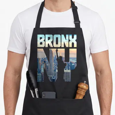 Bronx skyline new york apron - BRONX NY typography filled with NYC skyline showing Empire State Building and Statue — shown on a black cotton canvas apron against a white background