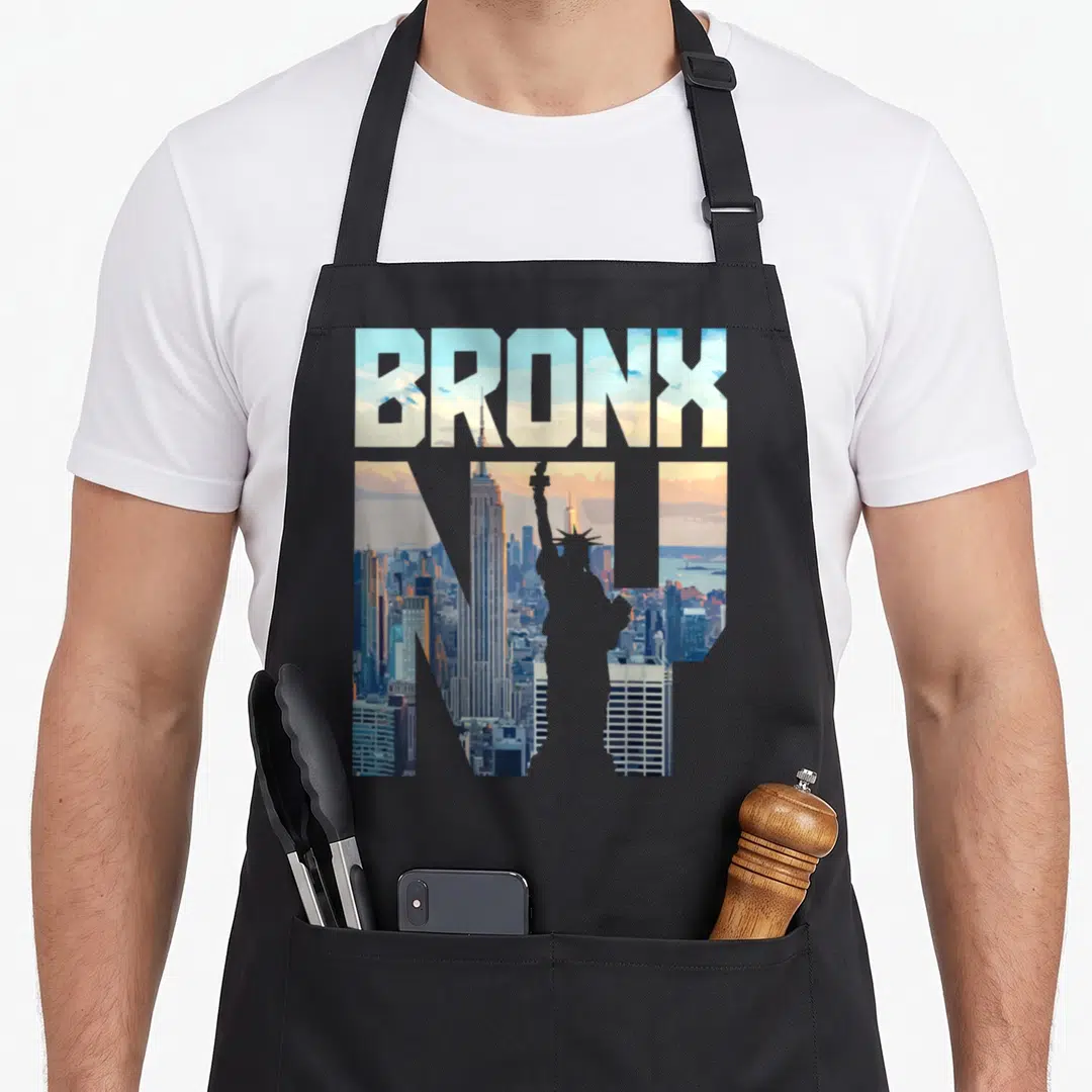 Bronx skyline new york apron - BRONX NY typography filled with NYC skyline showing Empire State Building and Statue — shown on a black cotton canvas apron against a white background