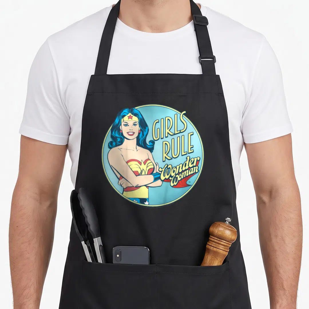 Rule single apron - Retro Wonder Woman portrait with stacked Girls Rule Wonder Woman text in a blue circle — shown on a black cotton canvas apron against a white background