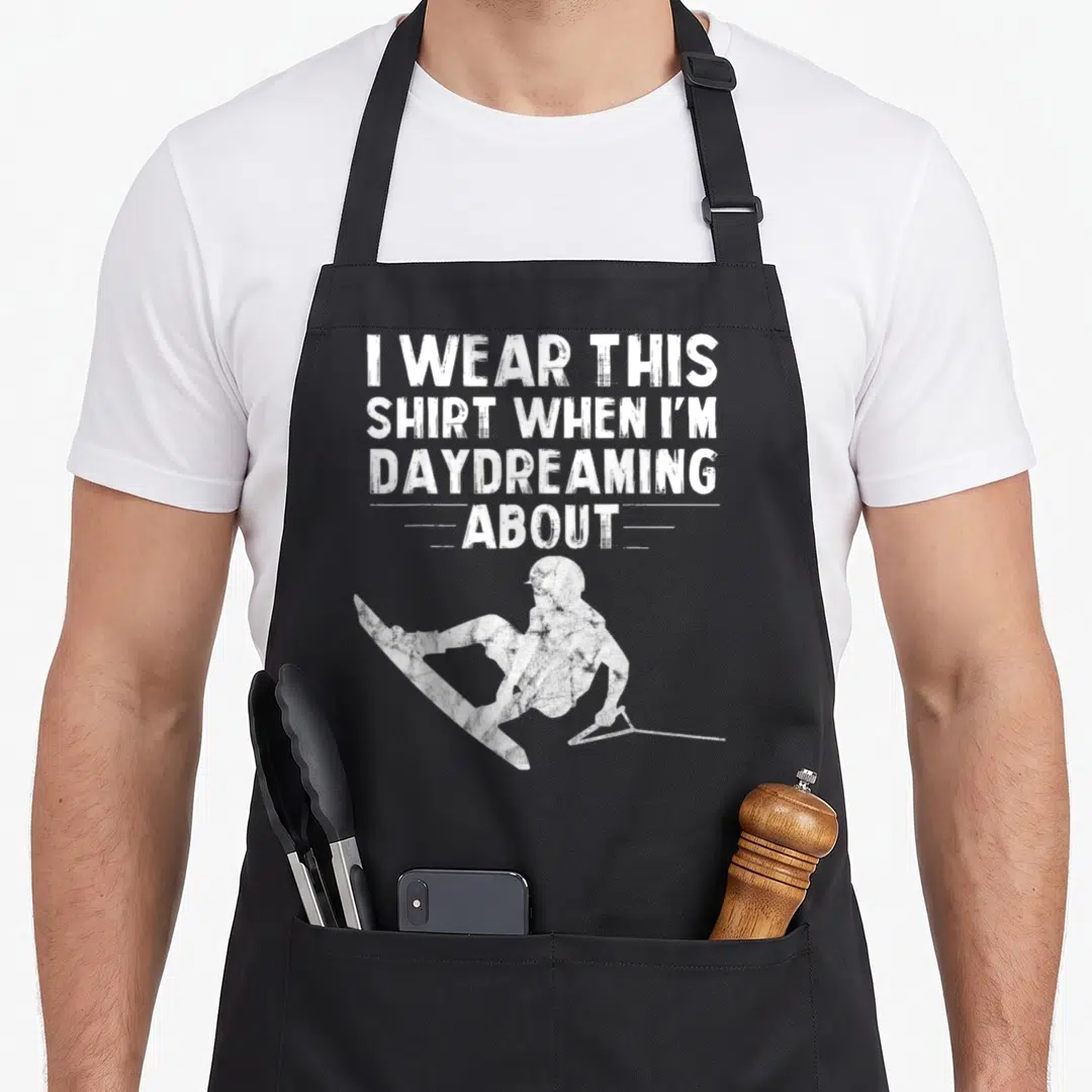 Wakeboarding christmas apron - Distressed white skier silhouette below stacked text reading I wear this shirt when I'm — shown on a black cotton canvas apron against a white background