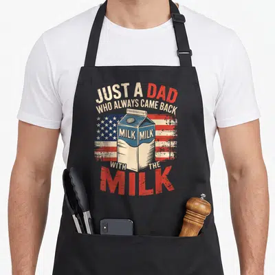 Father milk aprons - Distressed milk carton on USA flag with Just a Dad Who Always Came Back With The Milk text — shown on a black cotton canvas apron against a white background