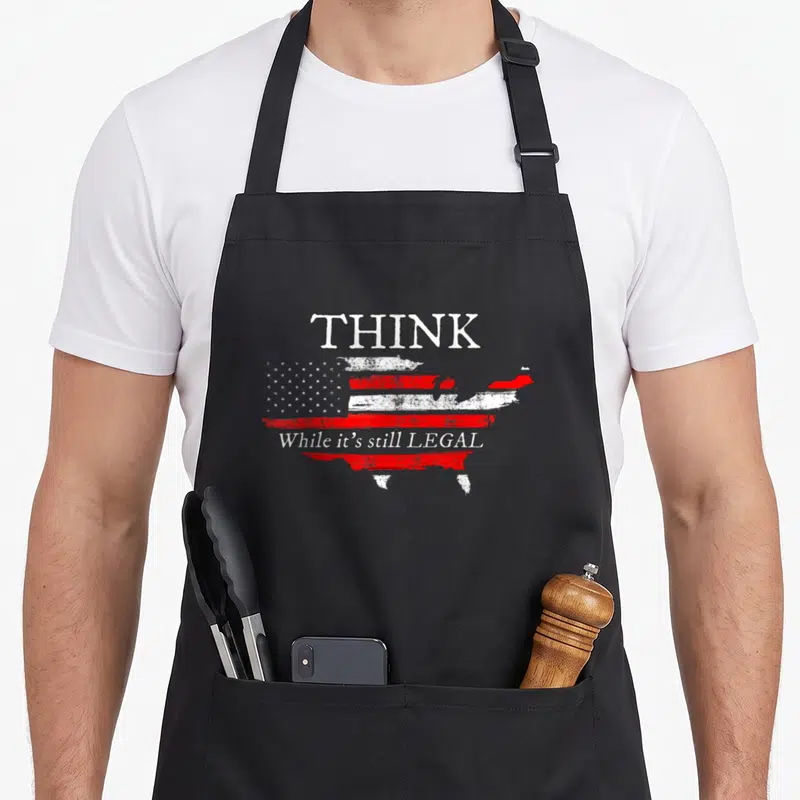 Legal patriotic apron - Distressed USA map shaped like a flag with white text THINK While it's still LEGAL — shown on a black cotton canvas apron against a white background
