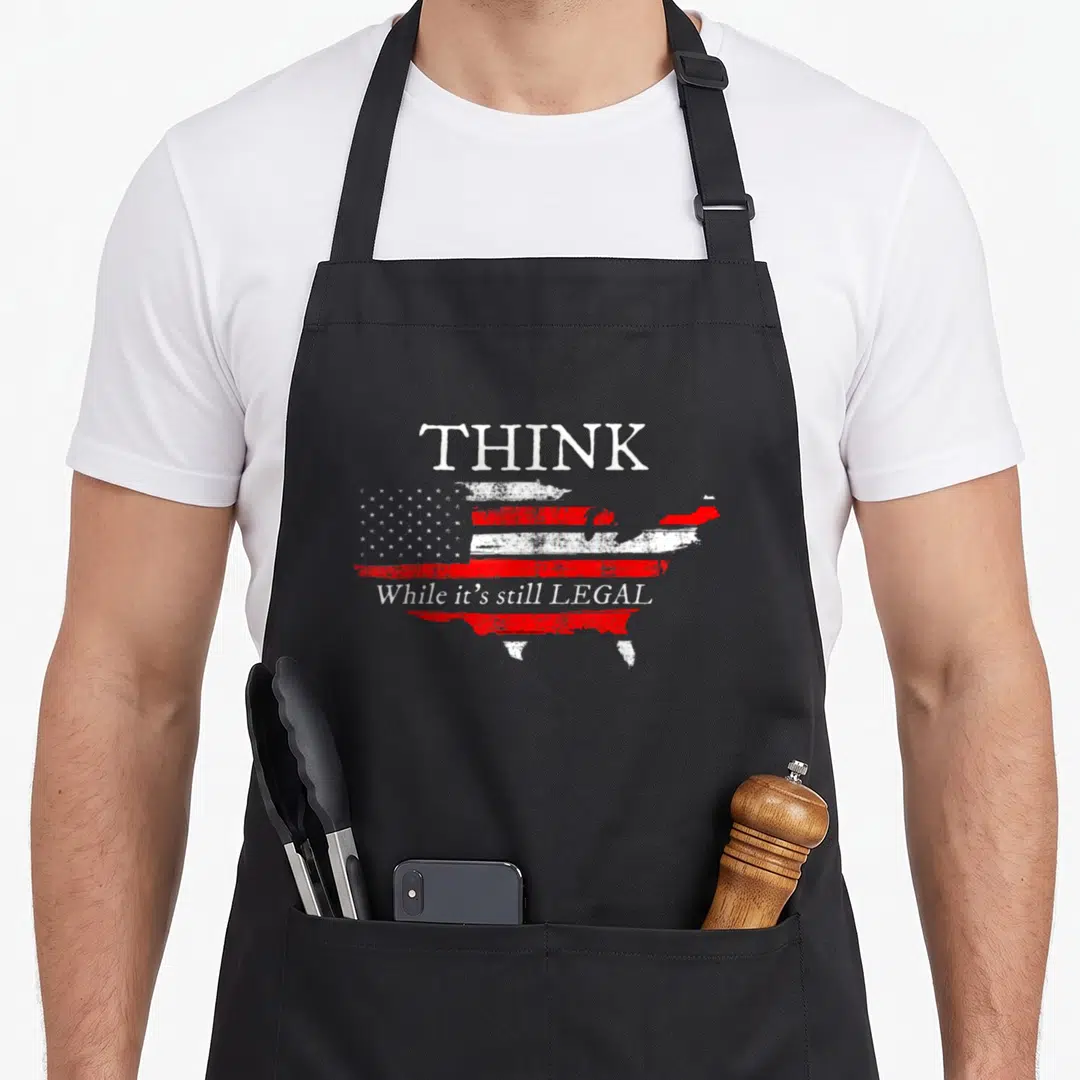 Legal patriotic apron - Distressed USA map shaped like a flag with white text THINK While it's still LEGAL — shown on a black cotton canvas apron against a white background