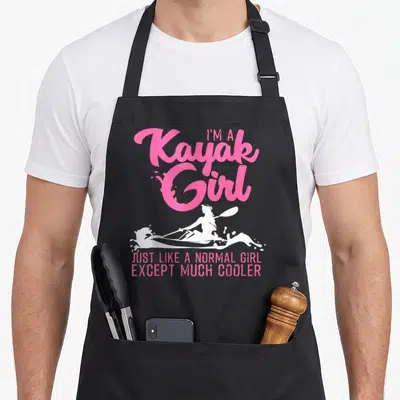 Paddling kayak apron - Pink text I'm A Kayak Girl above white female paddler silhouette and bottom slogan — shown on a black cotton canvas apron against a white background