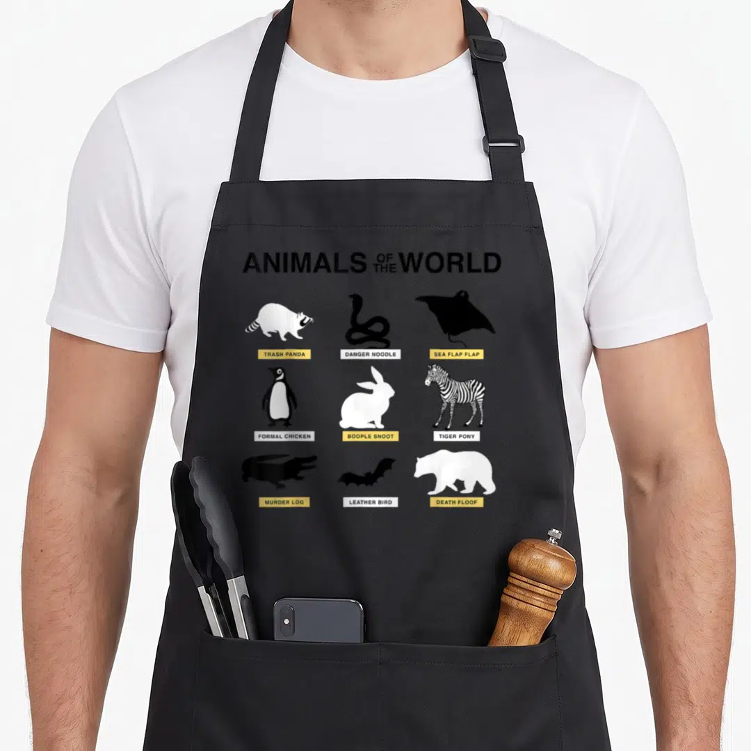 Animal meme apron - Minimalist animal silhouettes with labels Trash Panda, Danger Noodle, and Death Floof in black — shown on a black cotton canvas apron against a white background