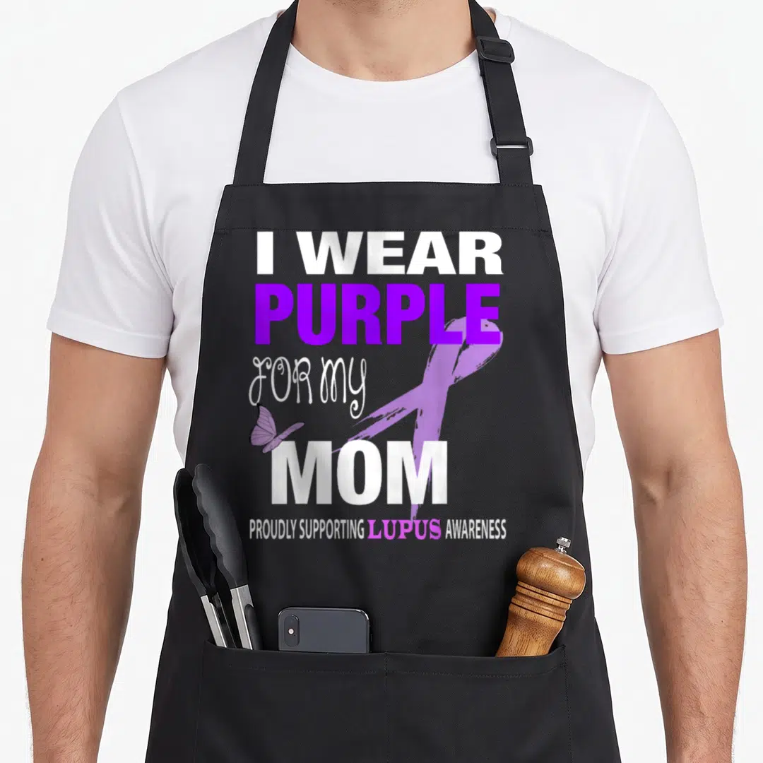 Cute lupus awareness apron - Purple ribbon butterfly and text I WEAR PURPLE FOR MY MOM on black apron — shown on a black cotton canvas apron against a white background