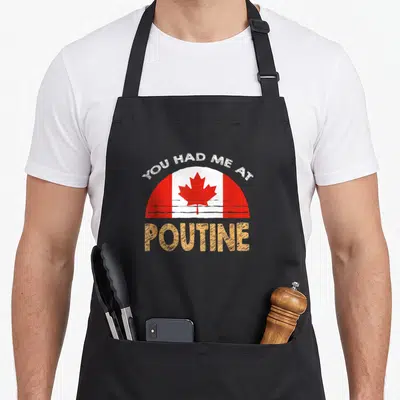 Canadian food aprons - Distressed You Had Me At Poutine text with red white Canadian flag graphic — shown on a black cotton canvas apron against a white background