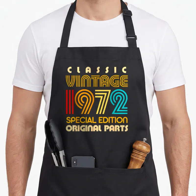Special parts of an apron - Stacked text reading Classic Vintage 1972 Special Edition Original Parts in retro yellow — shown on a black cotton canvas apron against a white background