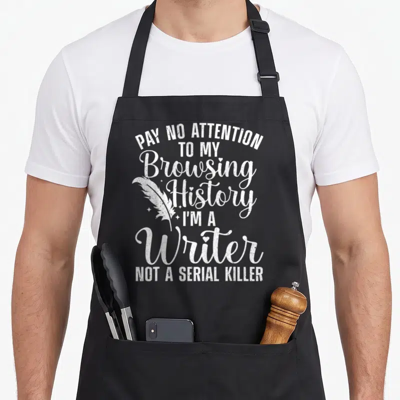 Author journalist apron - White stacked text reading Pay No Attention To My Browsing History I Am A Writer Not A Serial — shown on a black cotton canvas apron against a white background