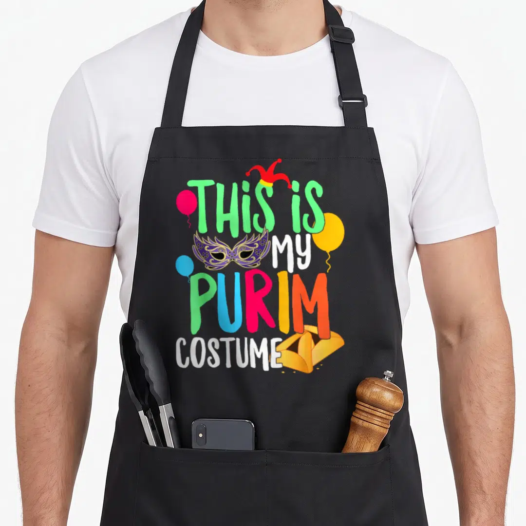 Costume jewish apron - Text reading This is MY PURIM COSTUME with jester hat mask balloons and hamantaschen in green — shown on a black cotton canvas apron against a white background