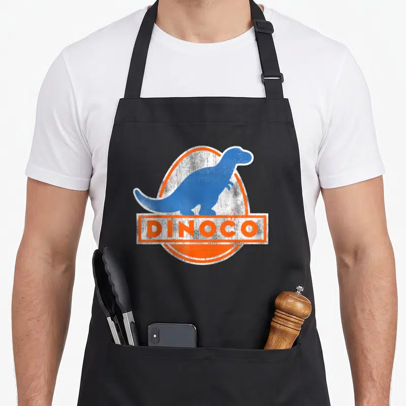 Iconic car apron - Blue dinosaur silhouette in orange oval with white DINOCO text box — shown on a black cotton canvas apron against a white background