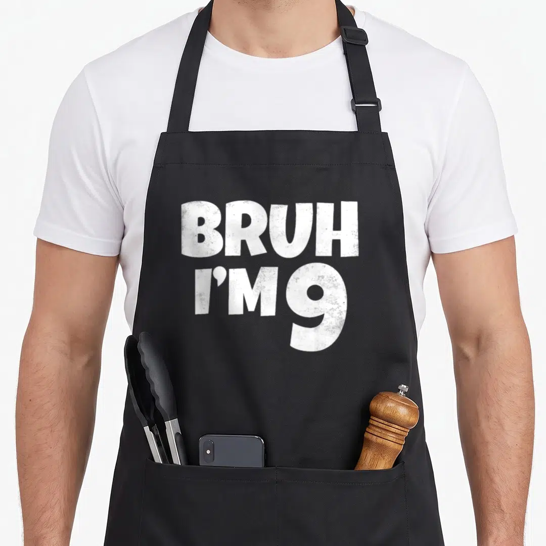 9th nine birthday apron - White distressed text reading BRUH I'M 9 stacked vertically — shown on a black cotton canvas apron against a white background