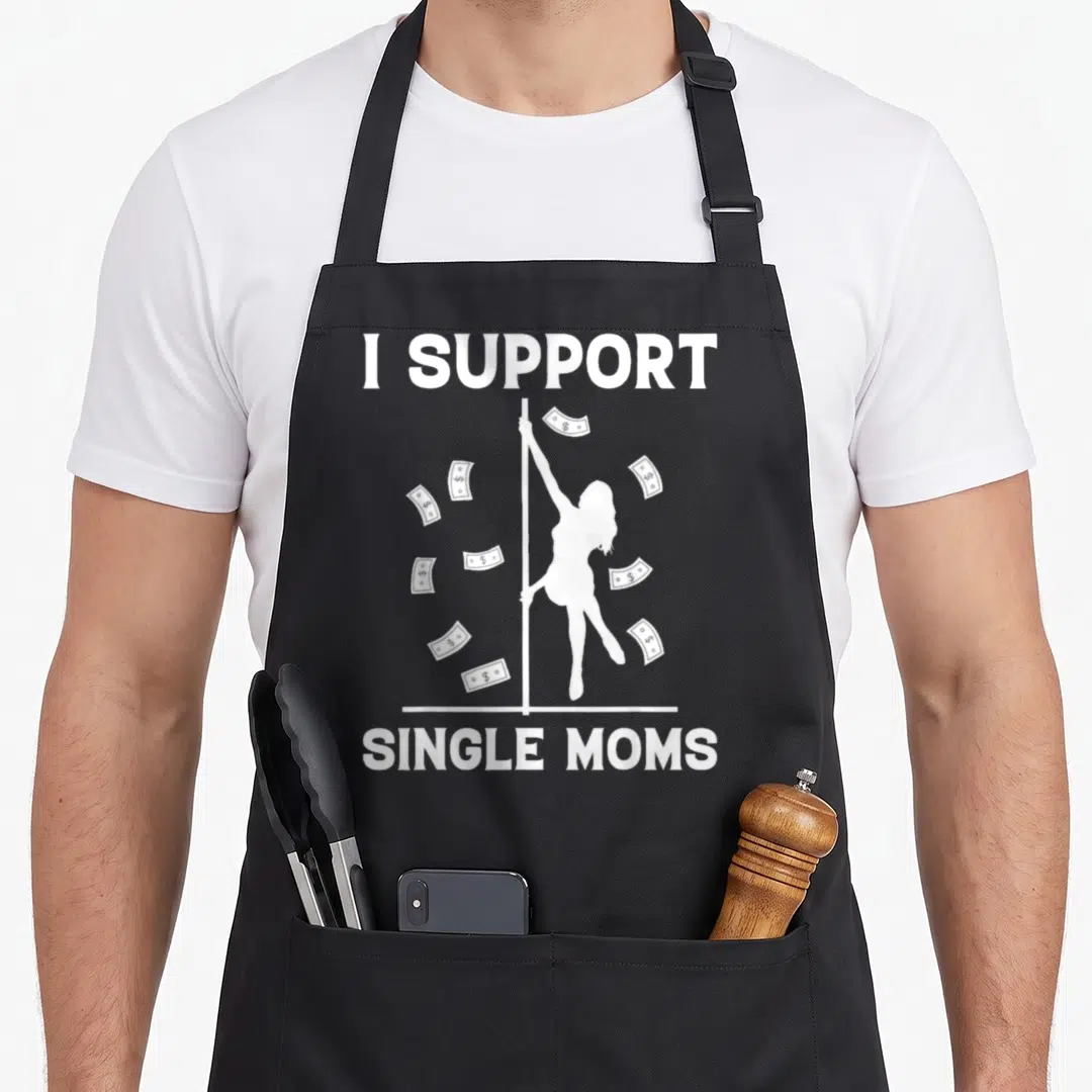Strip offensive aprons - White I SUPPORT SINGLE MOMS text with pole dancer silhouette and floating dollar bills — shown on a black cotton canvas apron against a white background