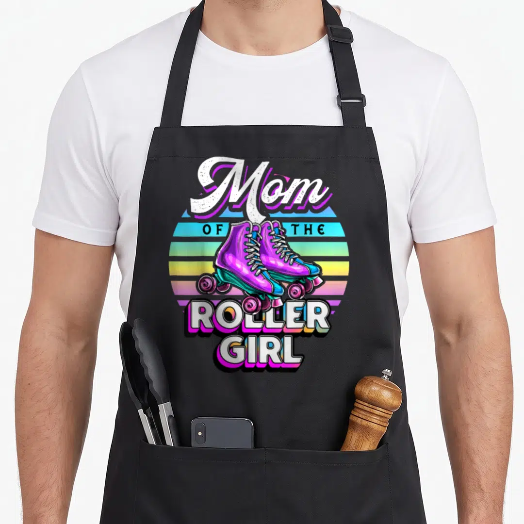 Roller skating family aprons - Mom of the Roller Girl text with purple skates on striped sunset background — shown on a black cotton canvas apron against a white background
