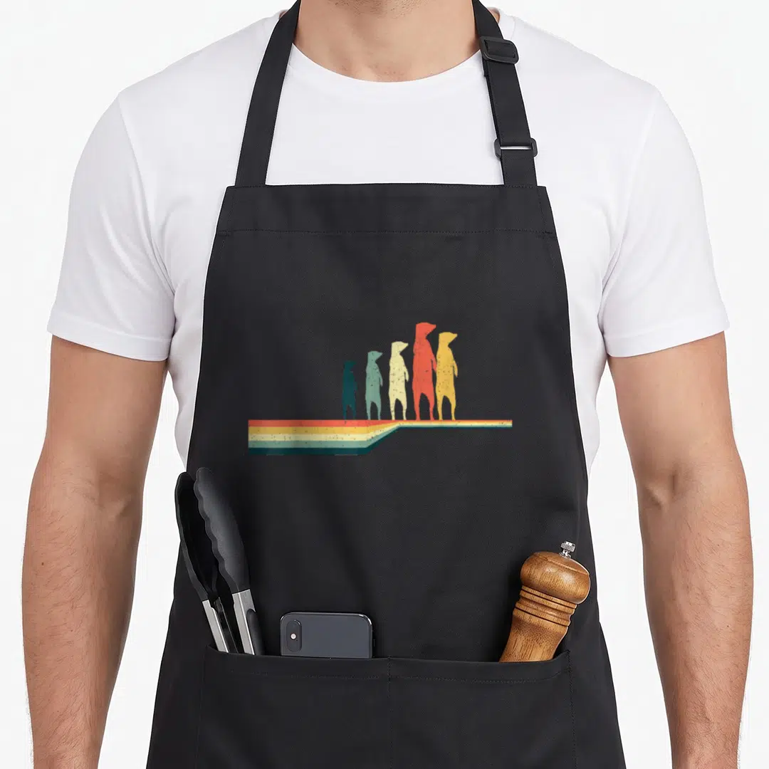Suricate animal apron - Five dog evolution silhouettes in red orange yellow green blue on multicolored striped platform — shown on a black cotton canvas apron against a white background