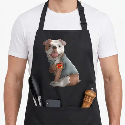 Bulldog tattoo english aprons - Cartoon bulldog in grey sweater with heart tattoo reading I LOVE MOM — shown on a black cotton canvas apron against a white background