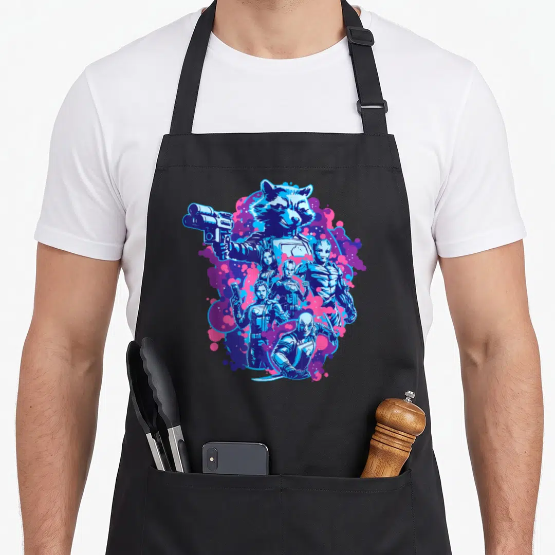 Volume galaxies apron - Rocket Raccoon holding gun above team figures against blue pink and purple splatter background — shown on a black cotton canvas apron against a white background