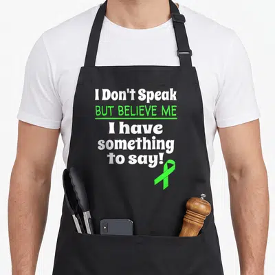 Non cerebral palsy awareness apron - Stacked white and lime green text with green awareness ribbon on black background — shown on a black cotton canvas apron against a white background