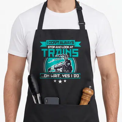 Alway boy train apron - Teal and white steam train graphic with sarcasm text and three stars on black background — shown on a black cotton canvas apron against a white background