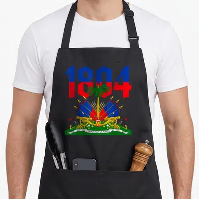 Revolution haitian apron - Coat of arms with 1804 text, palm tree, cannons, and L'UNION FAIT LA FORCE banner — shown on a black cotton canvas apron against a white background