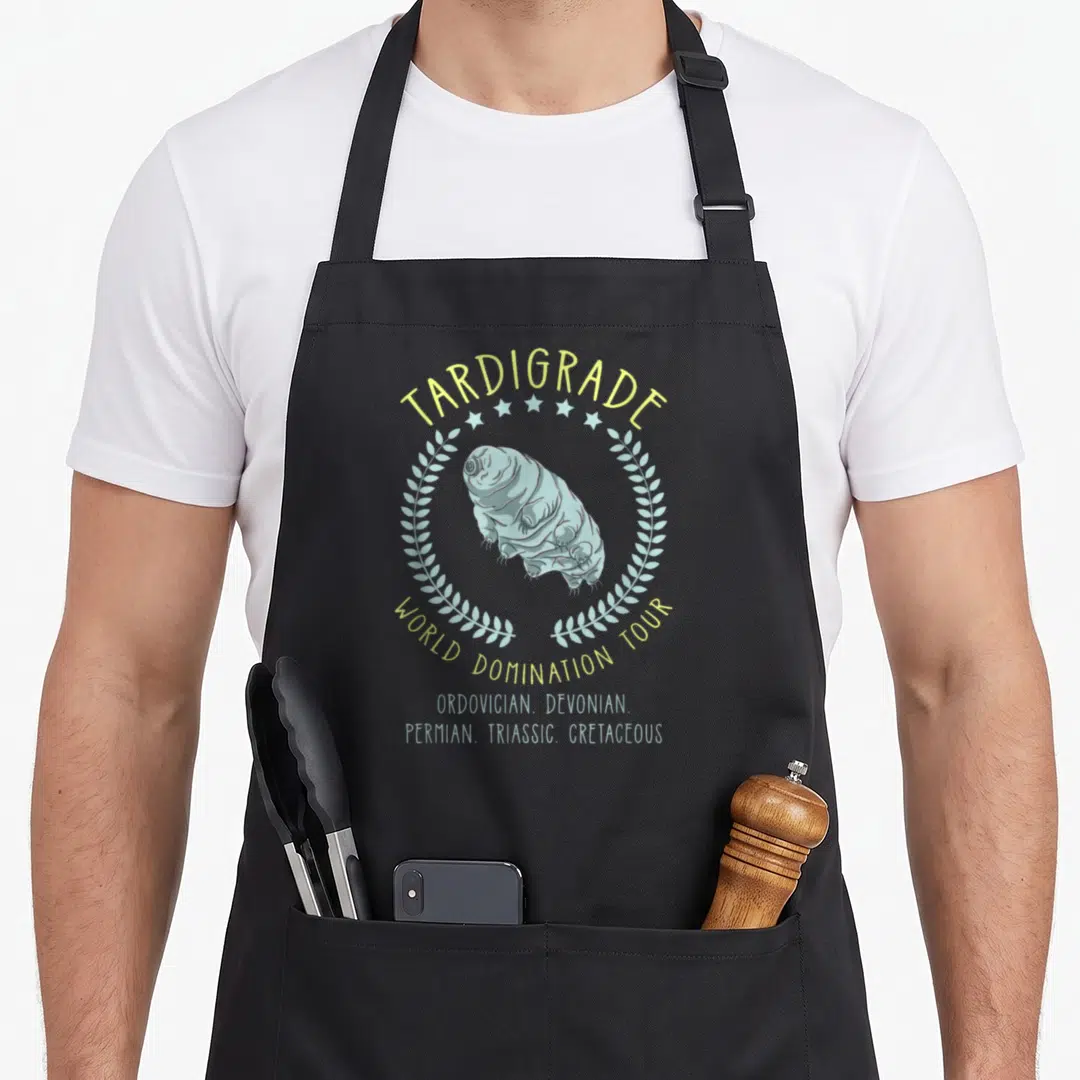 Tardigrade microbiologist apron - Blue tardigrade in yellow laurel wreath with world domination tour text — shown on a black cotton canvas apron against a white background
