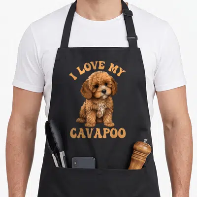 Cavapoo i love my dog apron - Realistic brown and white Cavapoo puppy with arched I LOVE MY CAVAPOO text — shown on a black cotton canvas apron against a white background