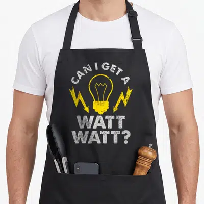 Watt electrician apron - Distressed light bulb and lightning bolts with text CAN I GET A WATT WATT? — shown on a black cotton canvas apron against a white background