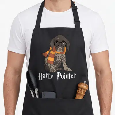 German pointer apron - Cartoon dog with glasses and striped scarf above Harry Pointer text — shown on a black cotton canvas apron against a white background