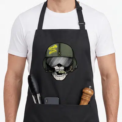 Grim aviation apron - Skull in olive flight helmet with yellow Death from Above text and grey visor — shown on a black cotton canvas apron against a white background