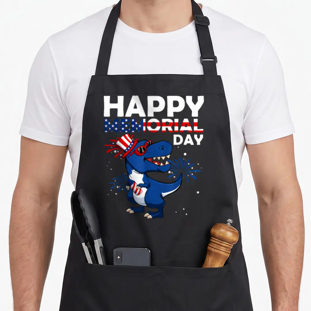 Hat 4th of july apron - Cartoon blue T-Rex in flag hat holding firework under stacked memorial day text — shown on a black cotton canvas apron against a white background