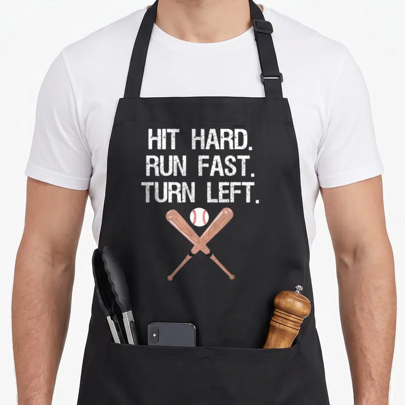 Fast baseball apron - Three lines of text above crossed brown bats and white ball with red stitching — shown on a black cotton canvas apron against a white background