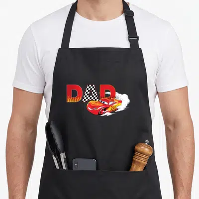 Funny car father day apron - DAD text with checkered A and red race car leaving white smoke trails — shown on a black cotton canvas apron against a white background