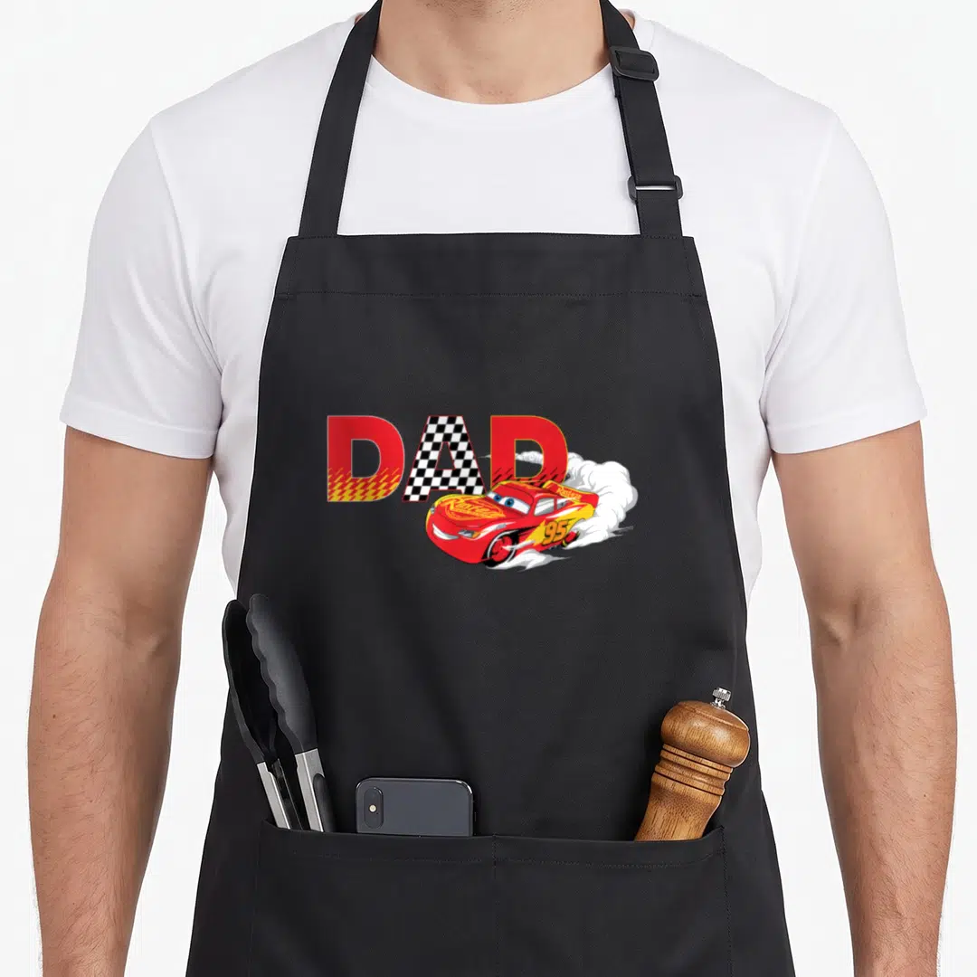 Funny car father day apron - DAD text with checkered A and red race car leaving white smoke trails — shown on a black cotton canvas apron against a white background
