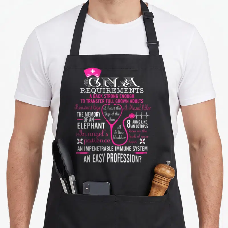 Requirement cna apron - Pink stethoscope heart surrounded by white and pink text listing CNA requirements — shown on a black cotton canvas apron against a white background
