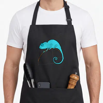 Chameleon golden apron - Blue chameleon perched on brown branch in grey rectangle with spiral tail — shown on a black cotton canvas apron against a white background