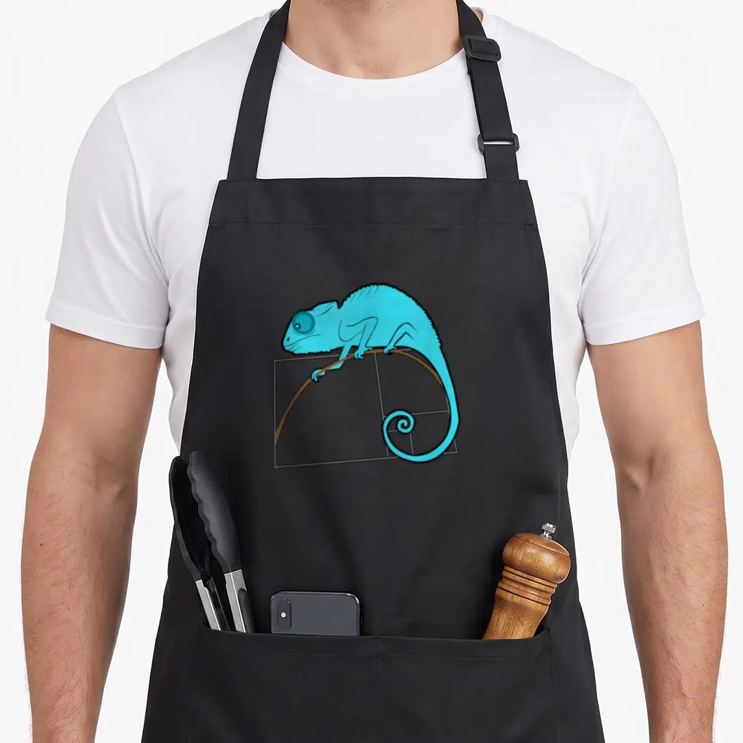 Chameleon golden apron - Blue chameleon perched on brown branch in grey rectangle with spiral tail — shown on a black cotton canvas apron against a white background
