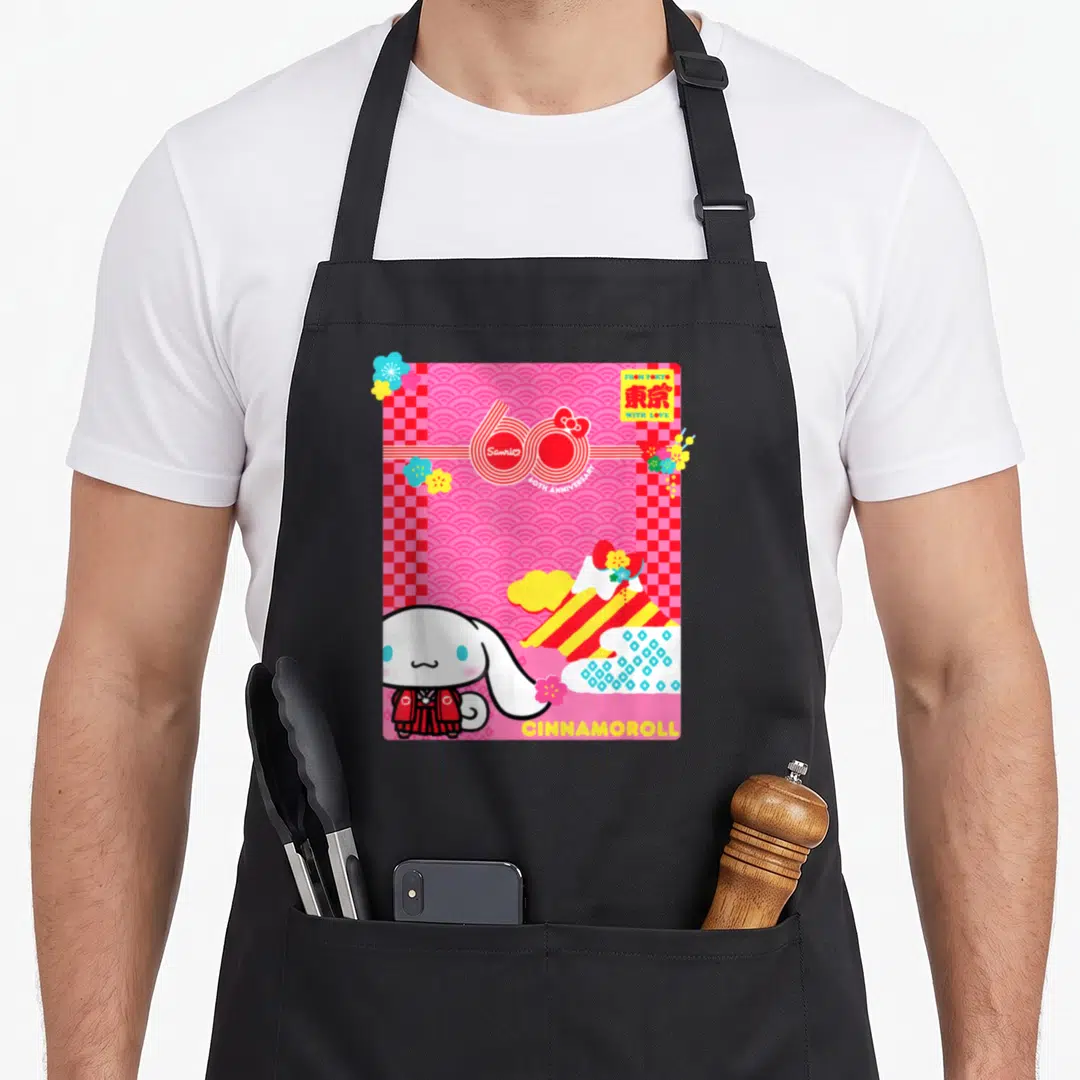 60th cinnamoroll apron - Pink and red cartoon design with Cinnamoroll character and 60th anniversary text — shown on a black cotton canvas apron against a white background