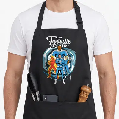 Fantastic four family aprons - Stacked white logo above four superheroes in blue and orange suits with The Thing in back — shown on a black cotton canvas apron against a white background