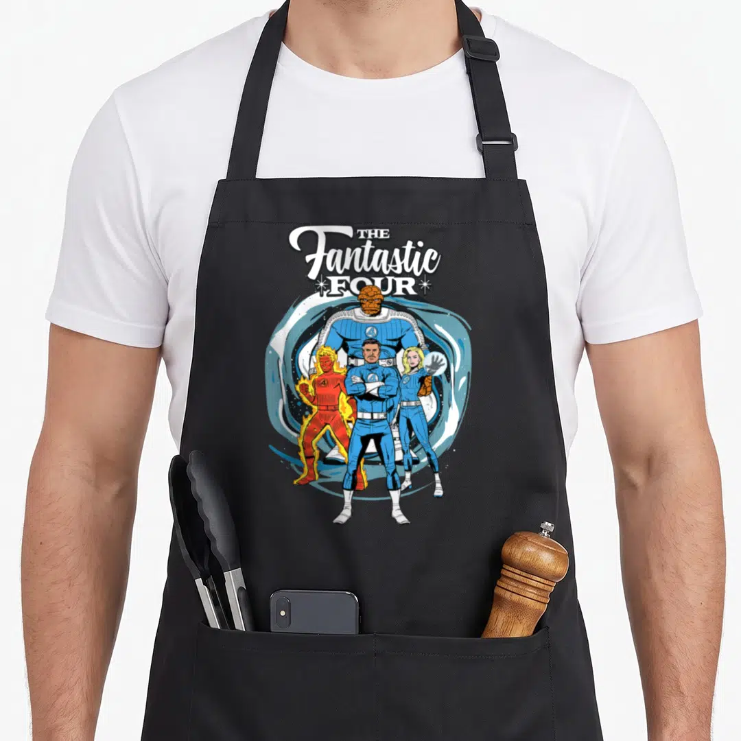 Fantastic four family aprons - Stacked white logo above four superheroes in blue and orange suits with The Thing in back — shown on a black cotton canvas apron against a white background